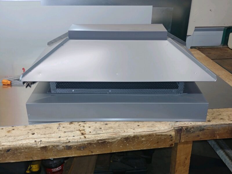 Custom fabricated chimney chase cover on a workbench