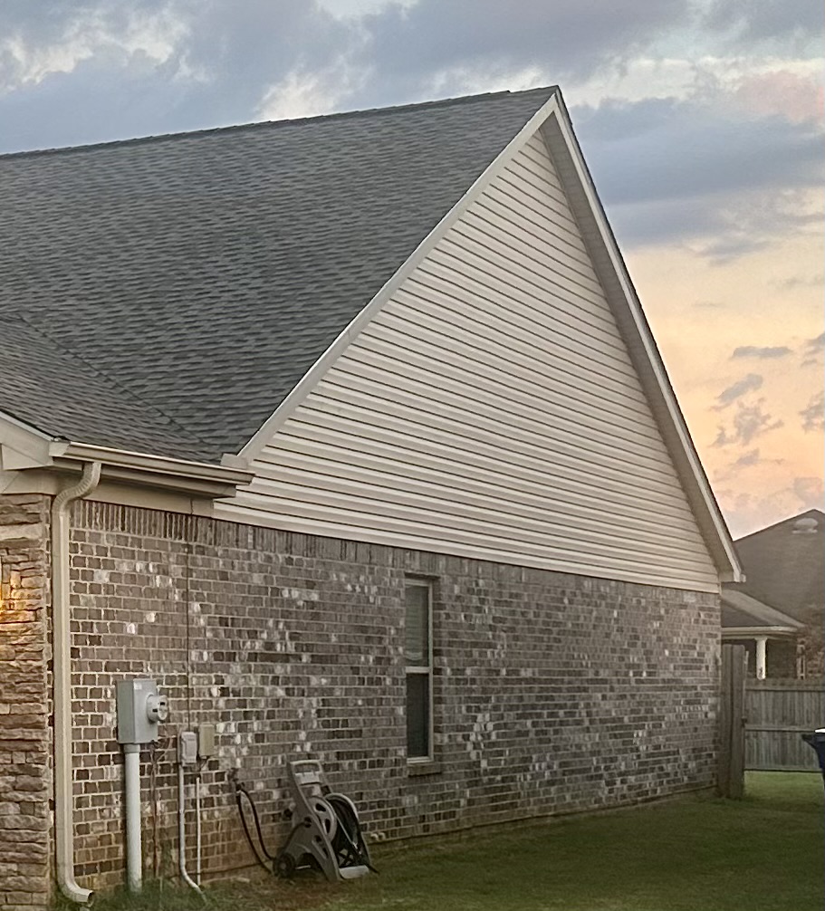 Cream colored vinyl siding on a brick house
