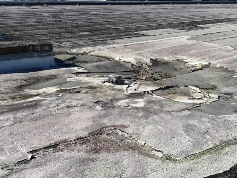 Damaged black Commercial flat rolled roof torch down