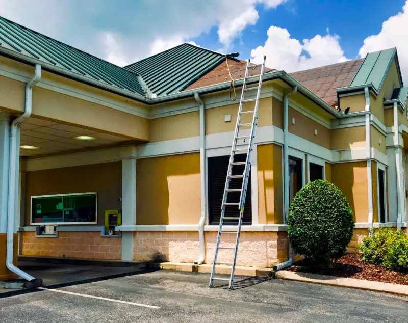 Huntsville roofing project: green standing seam metal roof being replaced on a commercial building