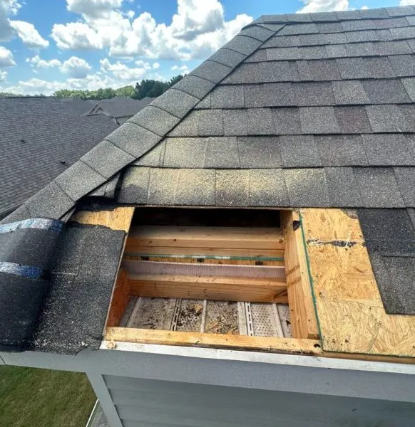 Roof repair in progress with damaged decking removed and new plywood being installed